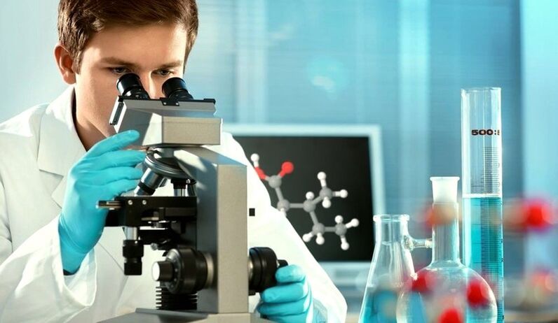 the specialist examines the material under a microscope